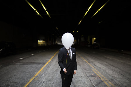 Anonymized Person with a white balloon in front of his head, ensuring his privacy